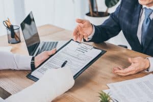 worker-broken-arm-signing-form-compensation-claim-businessman