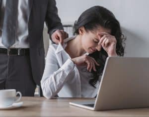 businessman-touching-blouse-dissatisfied-secretary-sitting-workplace-touching