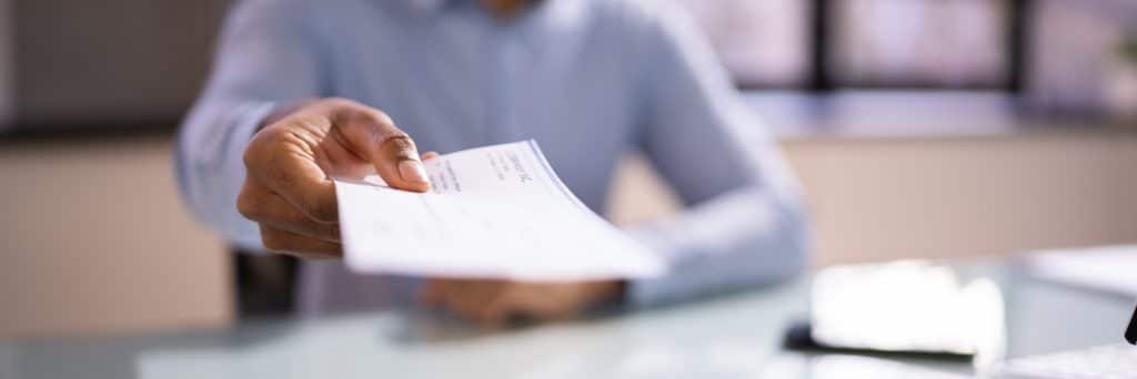 Hombre de Negocios Africano Dando Cheque de Pago o Nómina